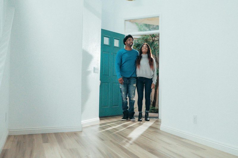 Cheerful couple in their new home, smiling and embracing the joy of homeownership.