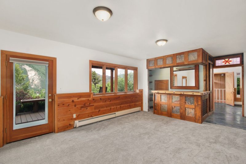 Spacious rustic apartment featuring wooden accents and a cozy built-in bar area.
