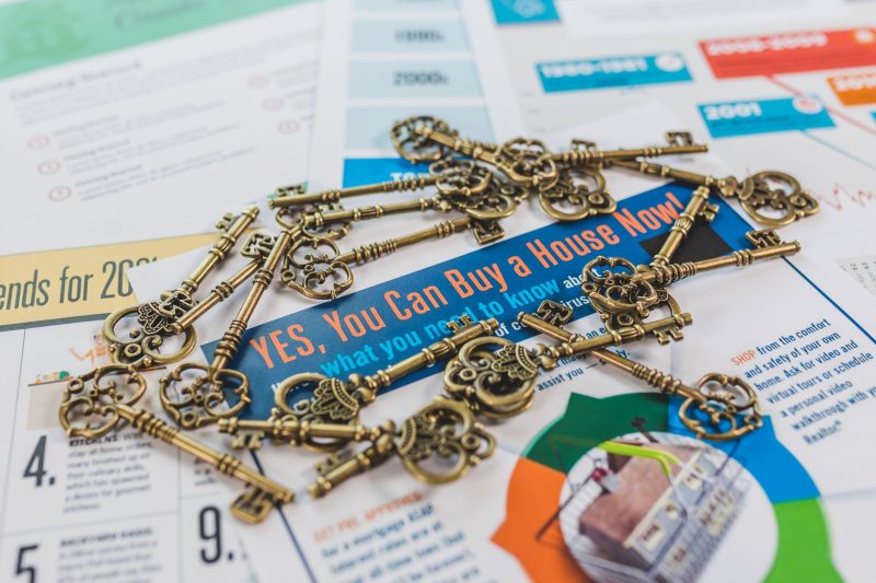 Home 3 A collection of vintage keys resting on a real estate brochure about house buying.