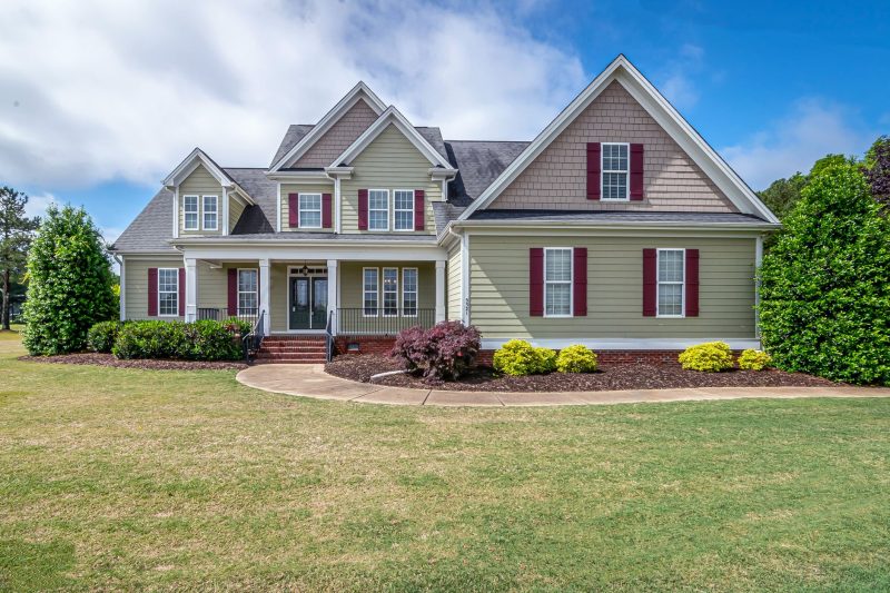 Home 3 Beautiful two-story suburban house with a manicured lawn and welcoming front porch.