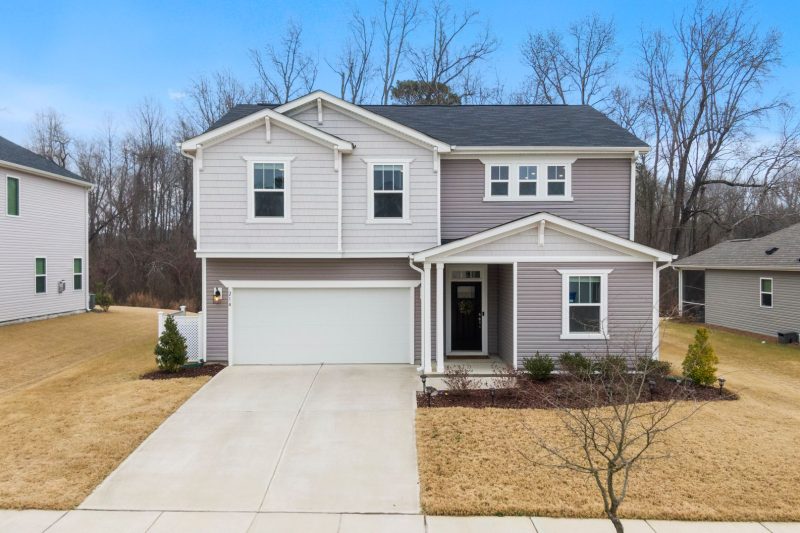 Home 3 Charming two-story suburban home with a garage, surrounded by greenery in Fuquay-Varina, NC.