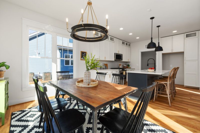 Home 3 Bright, modern kitchen and dining area with stylish furnishings and ample natural light.